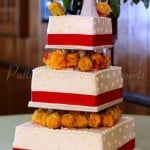 wedding-cake-red-ribbon-orange-flowers-white-cake
