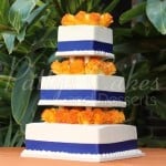 blue ribbon orange flowers white wedding cake